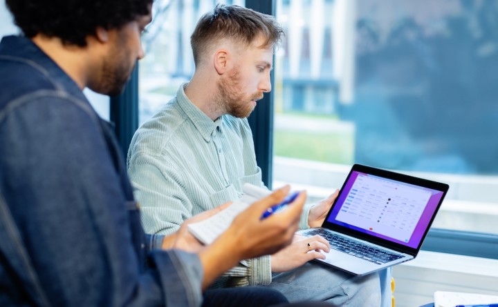 Twee mannen in een meeting werkend aan een laptop