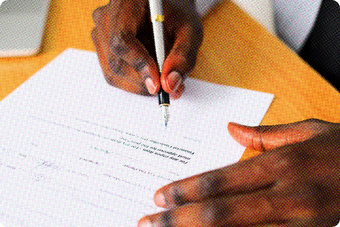 Two hands signing an employment contract.