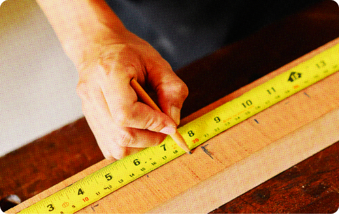 Image of a hand using a measuring tape